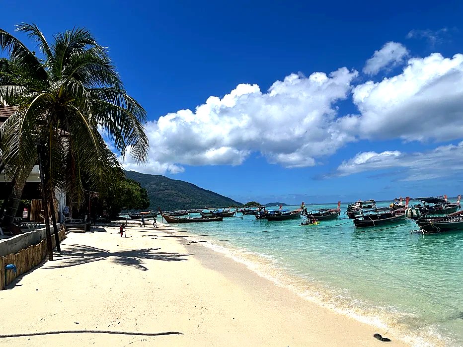 Aerial view of longtail boats on turquoise water at Sunrise Beach, Koh Lipe