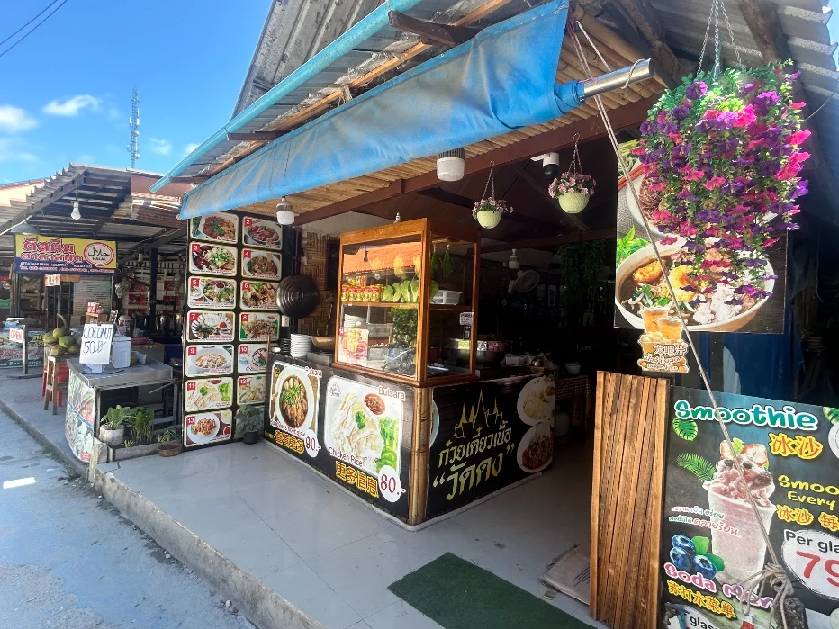 A small family-run Thai restaurant on Walking Street, Koh Lipe — open seating, handwritten menu