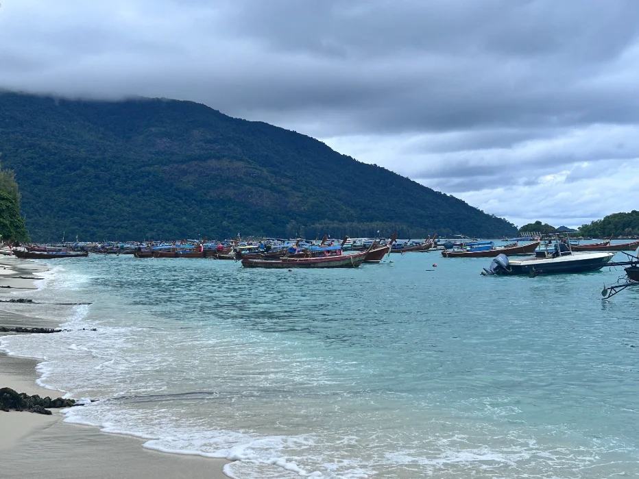 Longtail boats lined up along Sunrise Beach at first light, Koh Lipe